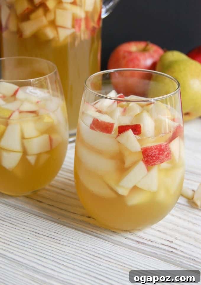 Bubbly Apple Pear Sangria 4 A pitcher of sparkling apple pear sangria with sliced fruit, ready to be served at a fall gathering.