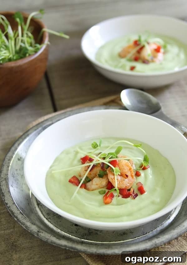 12 Superfood Avocado Recipes 3 Chilled Avocado Sweet Corn Soup with Lime Shrimp Salsa, a refreshing blend of creamy avocado and sweet corn, garnished with zesty lime shrimp.