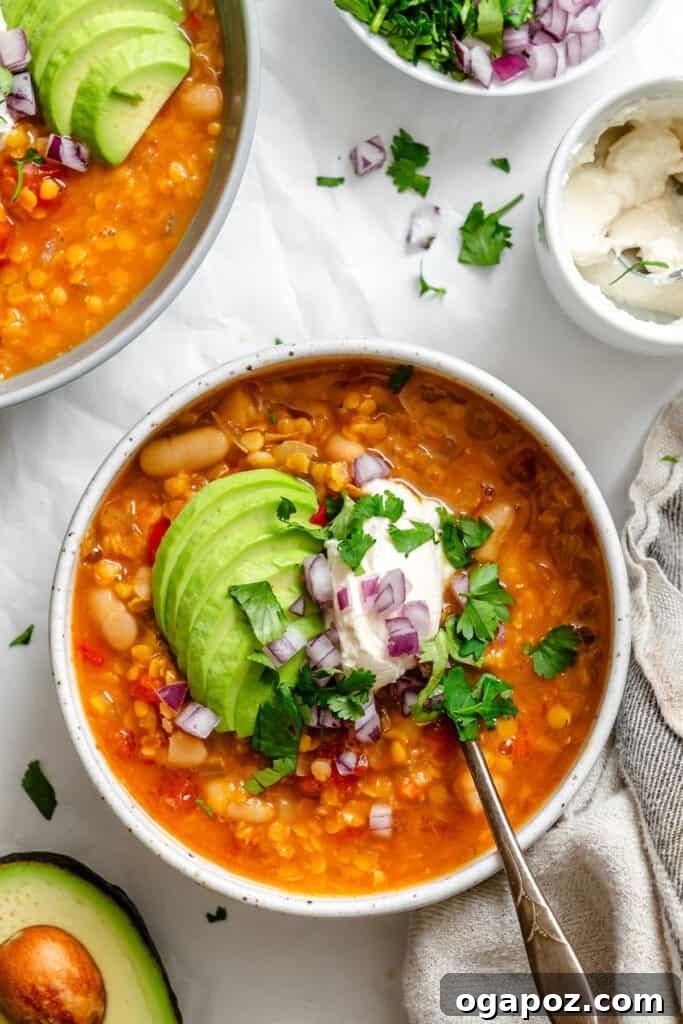 Hearty Lentil Chili 4 A bowl of Lentil Bean Chili topped with creamy Greek yogurt and sliced avocado, ready to be enjoyed.