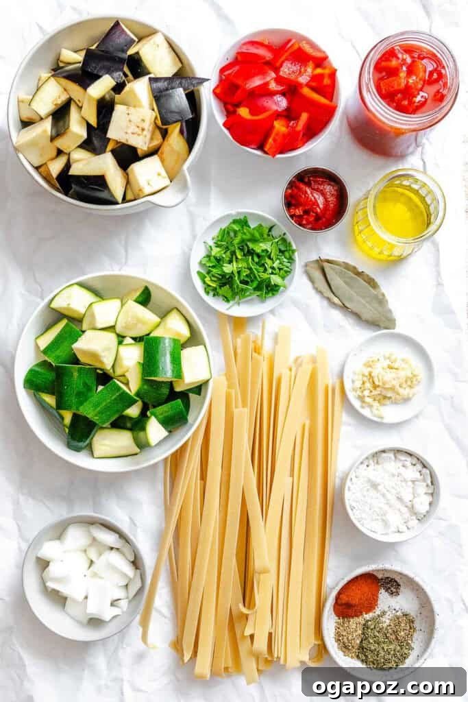 Provencal Garden Pappardelle 5 A thoughtfully arranged selection of fresh ingredients laid out, including garlic, sweet onion, tender eggplant, crisp zucchini, vibrant red bell peppers, canned diced tomatoes, tomato paste, and various fragrant herbs for the Ratatouille Pappardelle sauce.