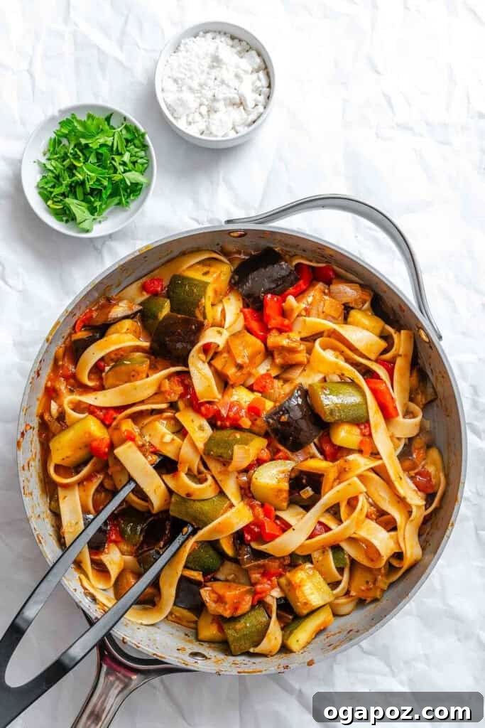 Provencal Garden Pappardelle 10 Cooked pappardelle pasta being gently tossed and combined with the rich ratatouille sauce in a large pan, ensuring every strand is coated.