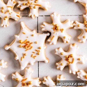 Snowflake cookies with royal icing and sprinkles on a table, a perfect festive treat.