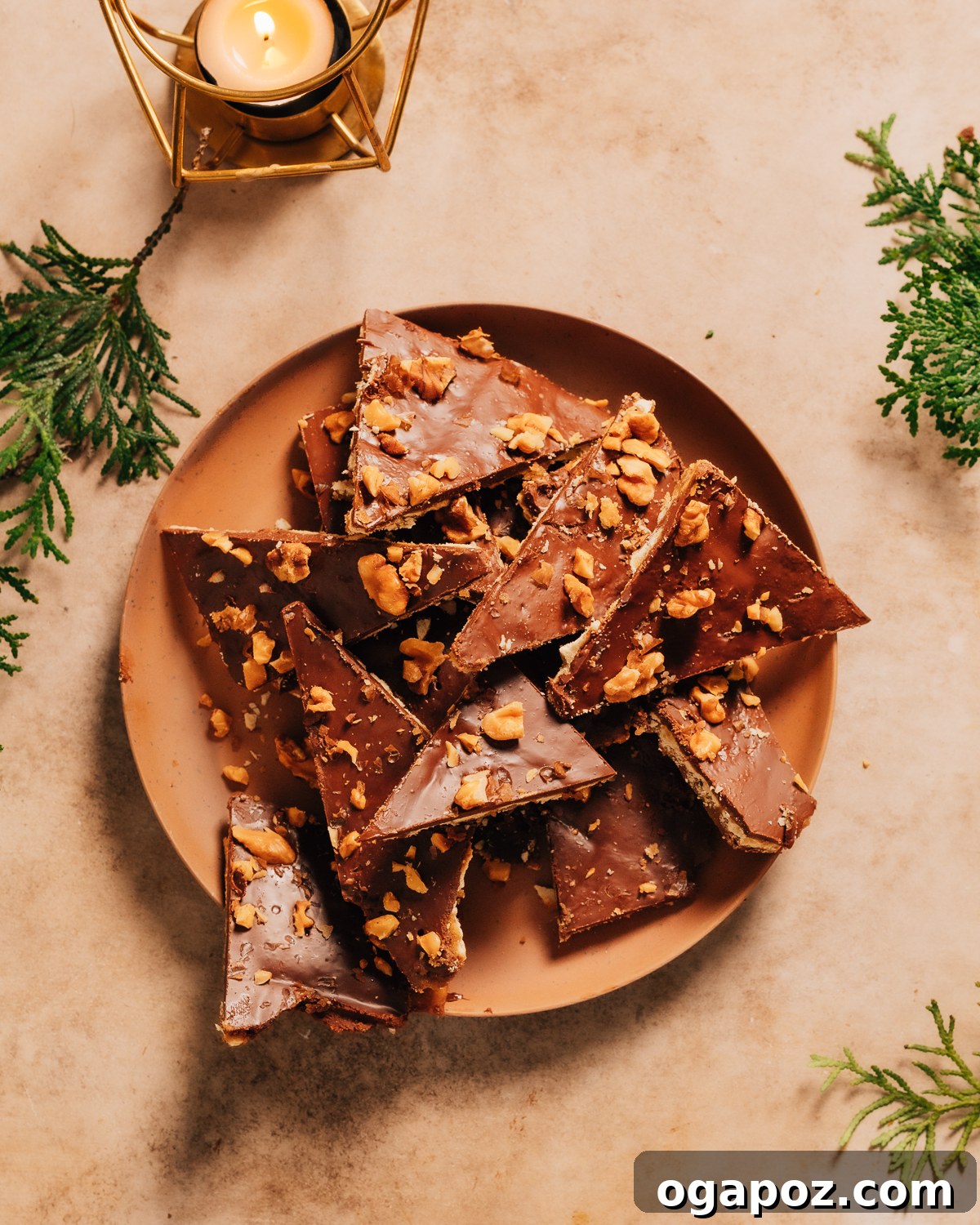 Effortless Chocolate Christmas Delights 3 A festive plate of Saltine cracker bark, covered in chocolate and toffee, garnished with Christmas greens.