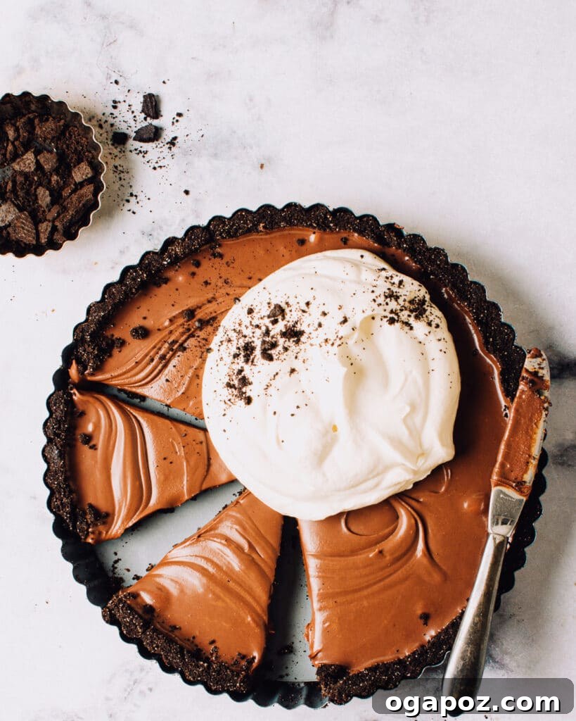 Effortless Chocolate Christmas Delights 4 Slices of a decadent chocolate ganache tart topped with whipped cream, ready to be served.