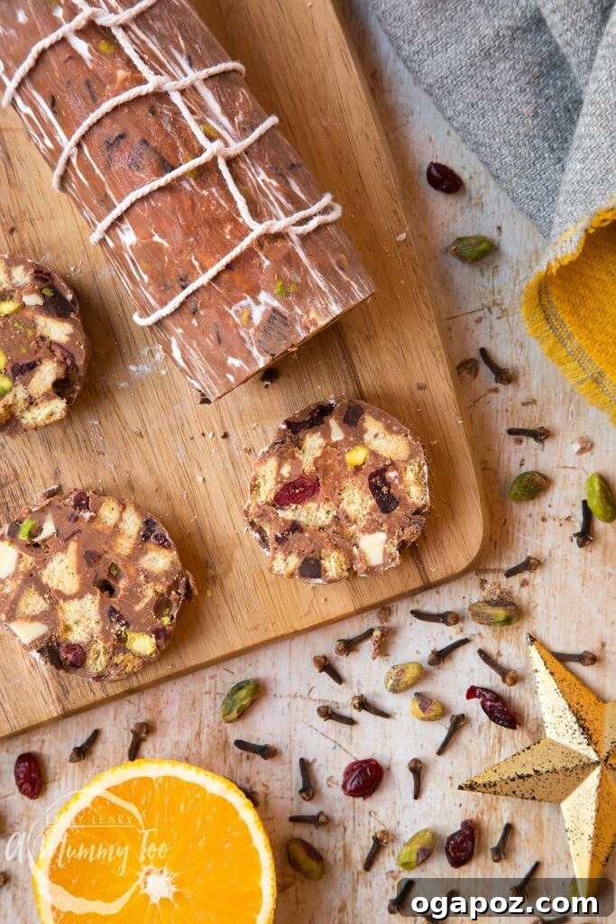 15 Italian Christmas Dessert Delights 12 Beautifully sliced pieces of Christmas spiced chocolate salami, arranged artfully on a rustic wooden board, showcasing its rich texture.