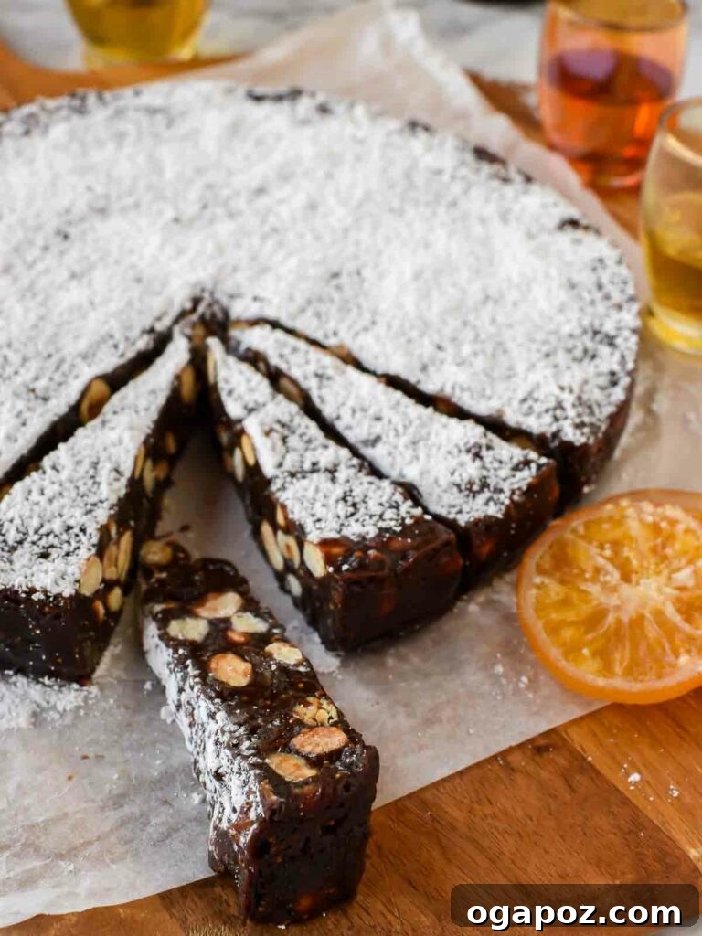 15 Italian Christmas Dessert Delights 8 Elegantly sliced triangle pieces of Panforte, richly packed with nuts and dried fruits, presented on parchment paper.