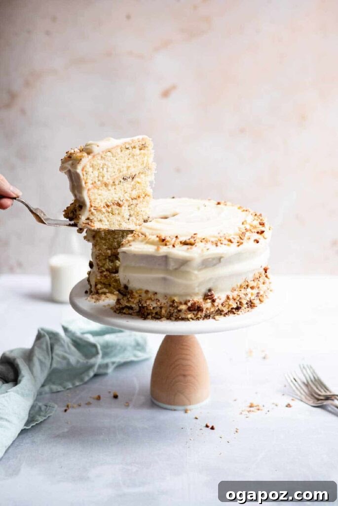 15 Italian Christmas Dessert Delights 10 A hand gently cutting into a towering 3-layer Italian cream cake, revealing its moist layers and creamy frosting.