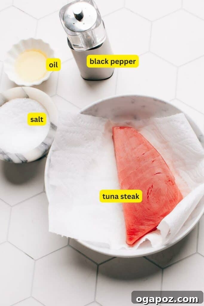 Flawless Air Fryer Tuna Steaks 3 Ingredients for Air Fryer Tuna Steak arranged on a kitchen countertop, including tuna steak, salt, black pepper, and oil.