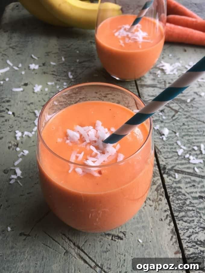 Vibrant Coconut Carrot Smoothie in a glass with a straw, garnished with shredded coconut