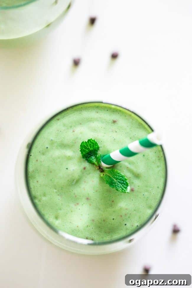 Vibrant Mint Chocolate Green Smoothie in a glass, topped with chocolate shavings