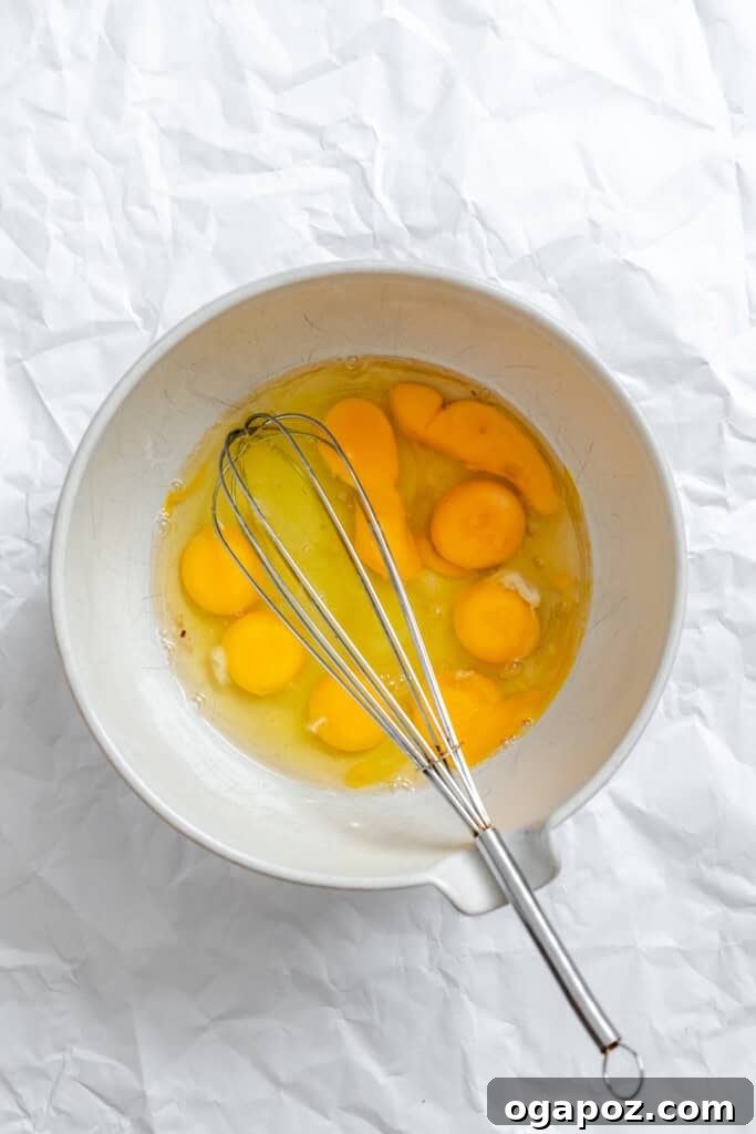 Tex-Mex Black Bean Egg Casserole with Zesty Verde 9 Eight eggs being whisked together in a mixing bowl.