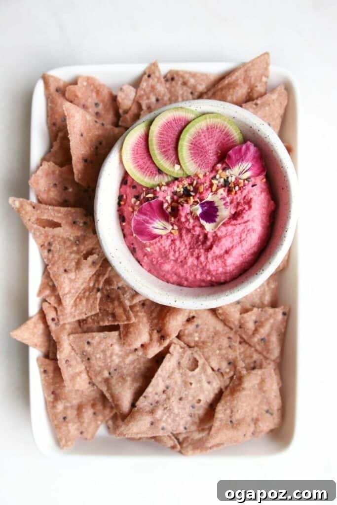 14+ Effortless Valentine's Day Family Feasts 19 A vibrant bowl of garlic beet hummus, perfectly served with crunchy potato chips for dipping.