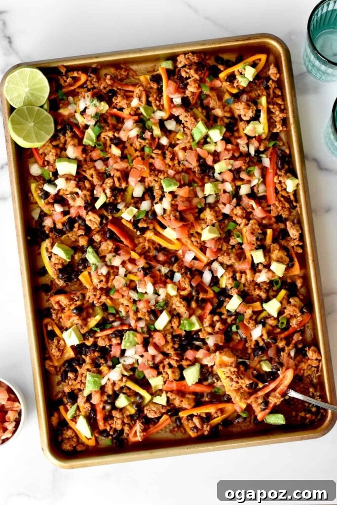 15 Easy Game Day Nachos Crowd Favorites 11 Top view of crunchy mini pepper nachos spread out on a baking sheet, colorful and appetizing.