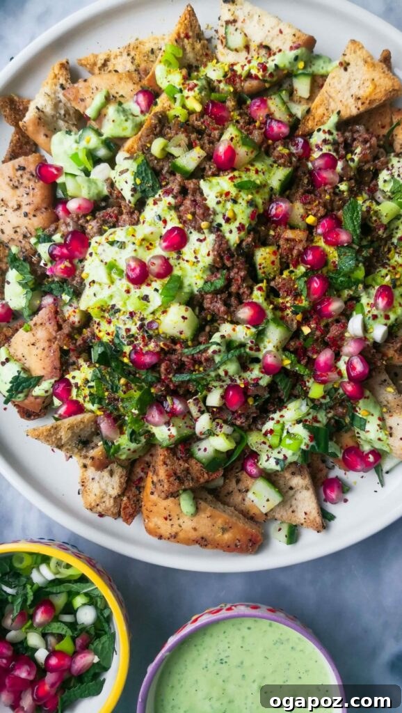 15 Easy Game Day Nachos Crowd Favorites 14 Sticky beef fatteh on a white ceramic plate served with salsa and dip