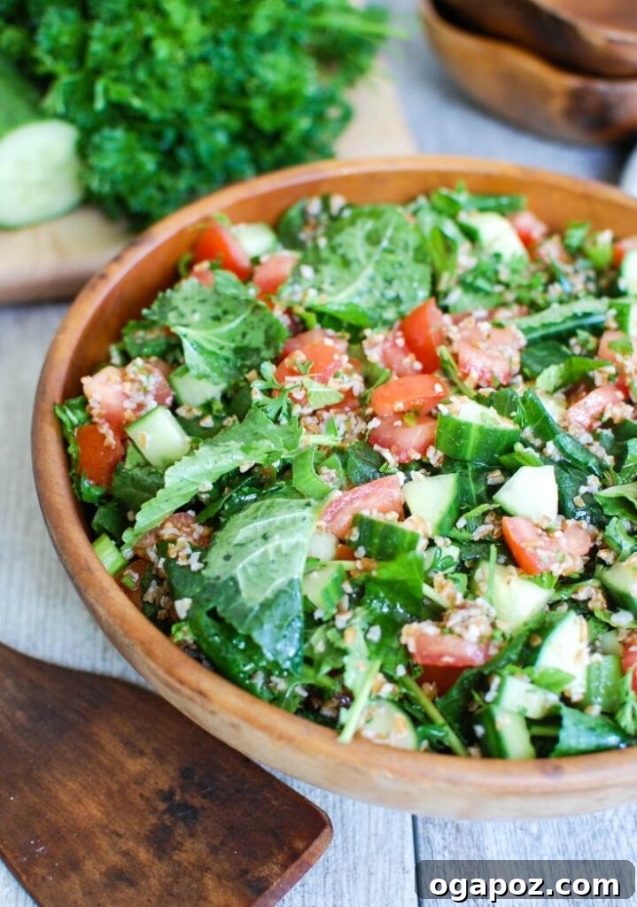 Vibrant Kale Cucumber Tabbouleh 3 Close-up of freshly prepared Kale Cucumber Tabbouleh in a bowl with a wooden serving spoon, highlighting the texture and vibrant colors