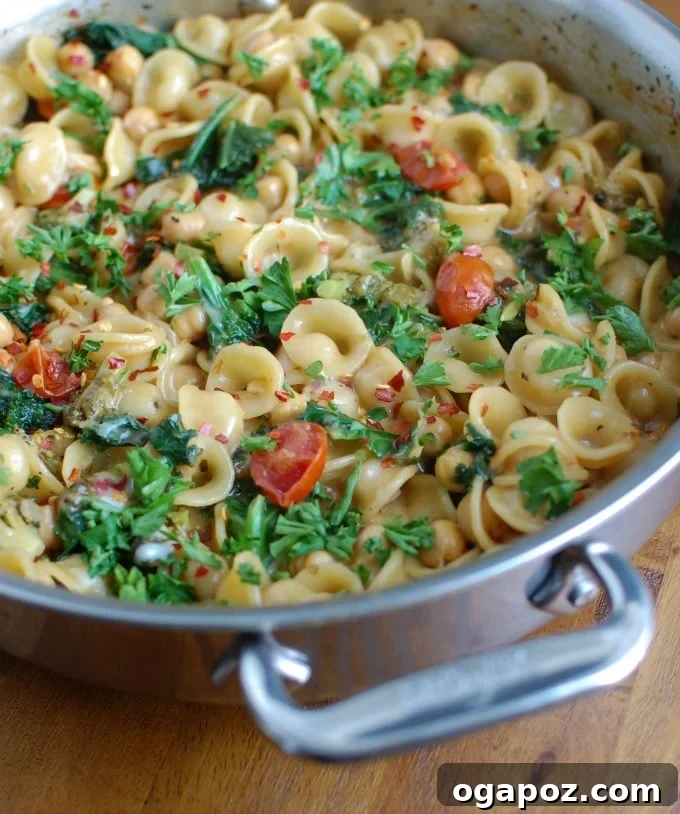 Effortless One-Pot Chickpea Kale Pasta 3 Close-up of One Pot Chickpea Kale Pasta garnished with fresh parsley, highlighting the texture of the pasta and vegetables.