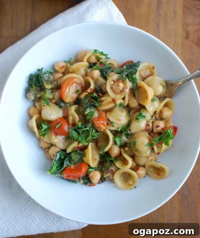 Effortless One-Pot Chickpea Kale Pasta 4 A bowl of One Pot Chickpea Kale Pasta, showcasing the mix of ingredients and a creamy sauce.