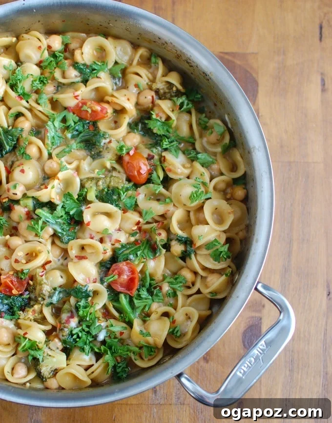 Effortless One-Pot Chickpea Kale Pasta 5 One Pot Chickpea Kale Pasta in a large skillet, with fresh cherry tomatoes visible among the ingredients.