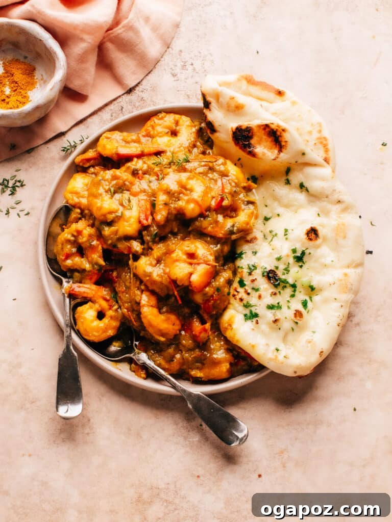 Flavorful Jamaican Curry Shrimp 6 A delicious plate of Jamaican Curry Shrimp served alongside fluffy white rice and warm flatbread.