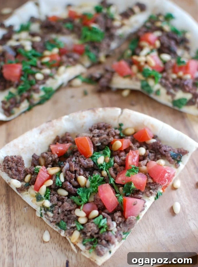Spiced Beef and Hummus Pita Pizza sliced into wedges on a platter.
