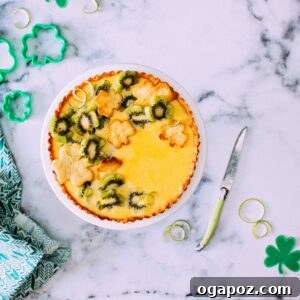 A full view of the delicious Kiwi & Lime Curd Tart, showcasing its vibrant green kiwi slices arranged artfully on top of the creamy lime filling within a golden-brown crust.