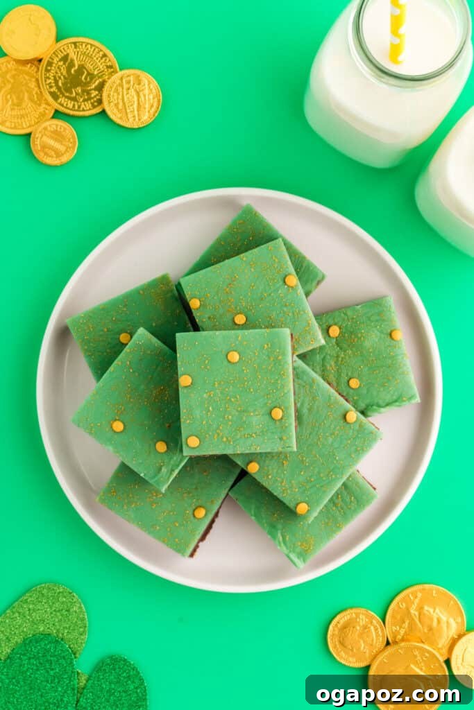 Luck of the Irish: Delicious Green Desserts for St Patricks Day 17 Stack of chocolate mint fudge squares on a white plate, with chocolate gold coins arranged around them, a rich and festive green dessert for St. Patrick's Day.