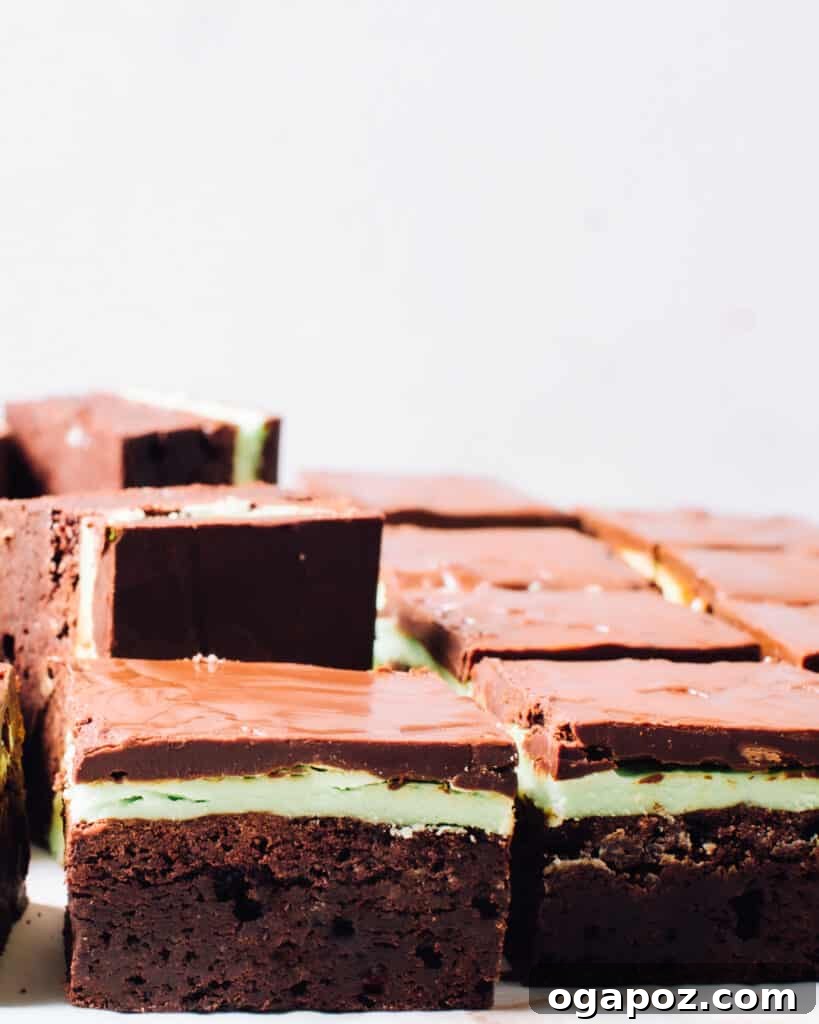 Luck of the Irish: Delicious Green Desserts for St Patricks Day 3 Side view of square-shaped mint chocolate brownies, featuring a dark chocolate base, a green mint icing layer, and a top chocolate glaze. A perfect St. Patrick's Day dessert.