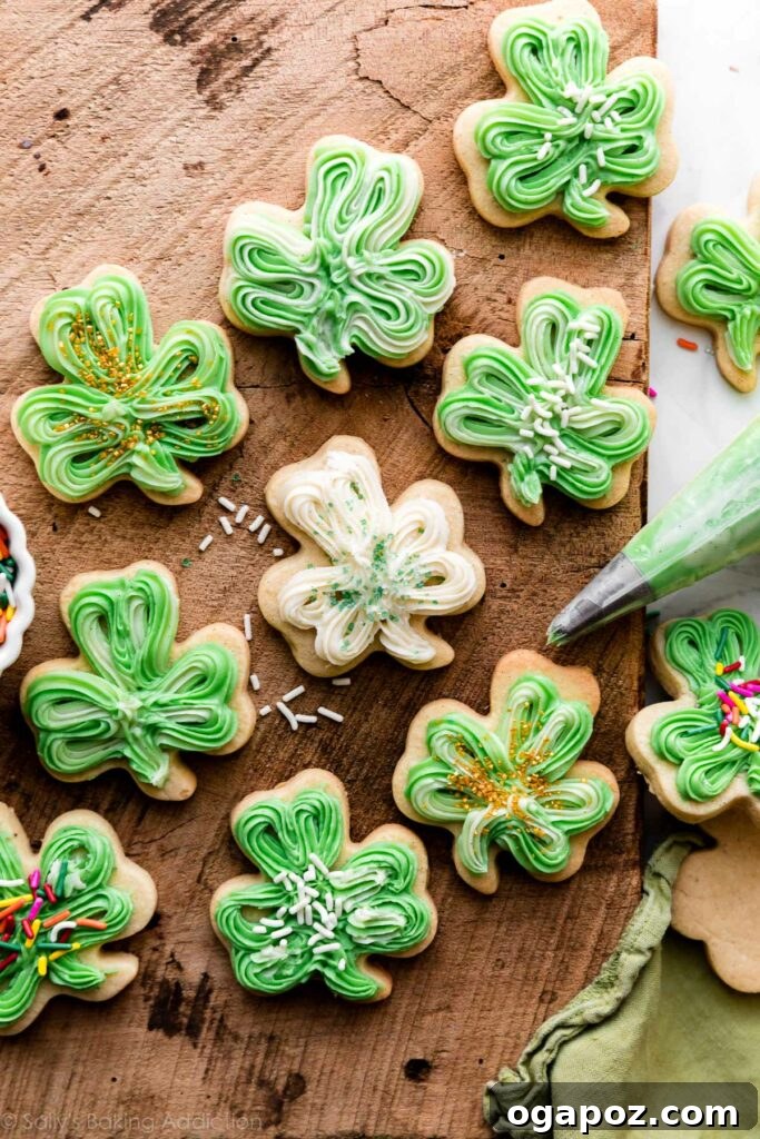 Luck of the Irish: Delicious Green Desserts for St Patricks Day 5 Shamrock-shaped vanilla bean St. Patrick's Day sugar cookies on a brown wooden surface, topped with creamy frosting. A lovely green dessert idea.