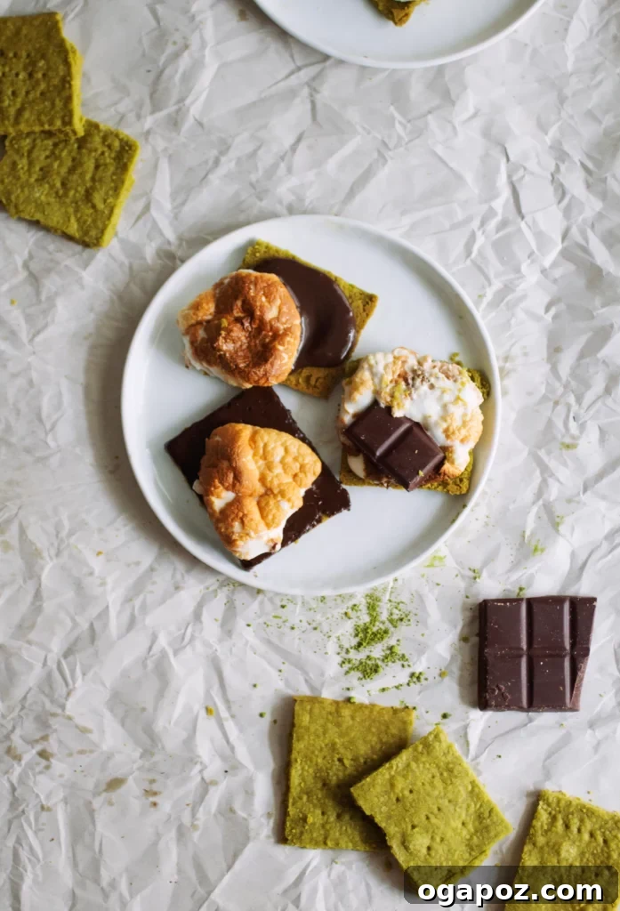 Luck of the Irish: Delicious Green Desserts for St Patricks Day 10 Matcha shortbread cookies topped with s'mores and melted chocolate on a white plate, offering a unique green dessert for St. Patrick's Day.