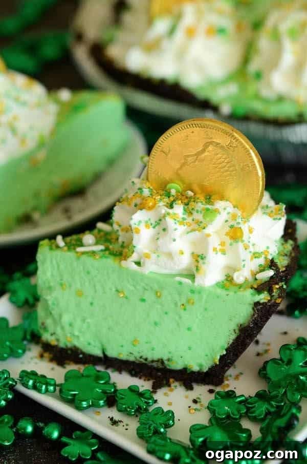 Luck of the Irish: Delicious Green Desserts for St Patricks Day 11 A slice of no-bake shamrock freezer pie with whipped cream and a chocolate gold coin on top, perfect for a refreshing St. Patrick's Day dessert.