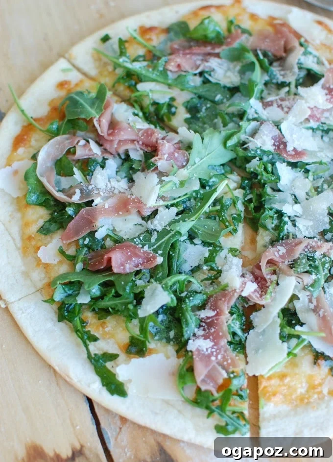 Gourmet Prosciutto Arugula Pizza 5 A close-up of Prosciutto Arugula Pizza with fresh arugula scattered on top.