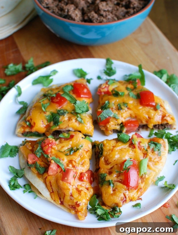 Delicious homemade Mexican Pizza, featuring two crispy tortilla layers filled with seasoned ground beef, refried beans, and melted cheese, topped with fresh garnishes.