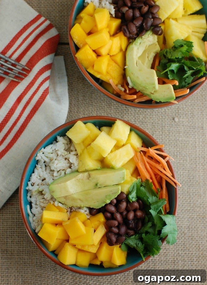 Tropical Coconut Rice Bliss 3 Close-up of a Tropical Coconut Rice Bowl showcasing perfectly sliced avocado alongside tropical fruits and black beans.