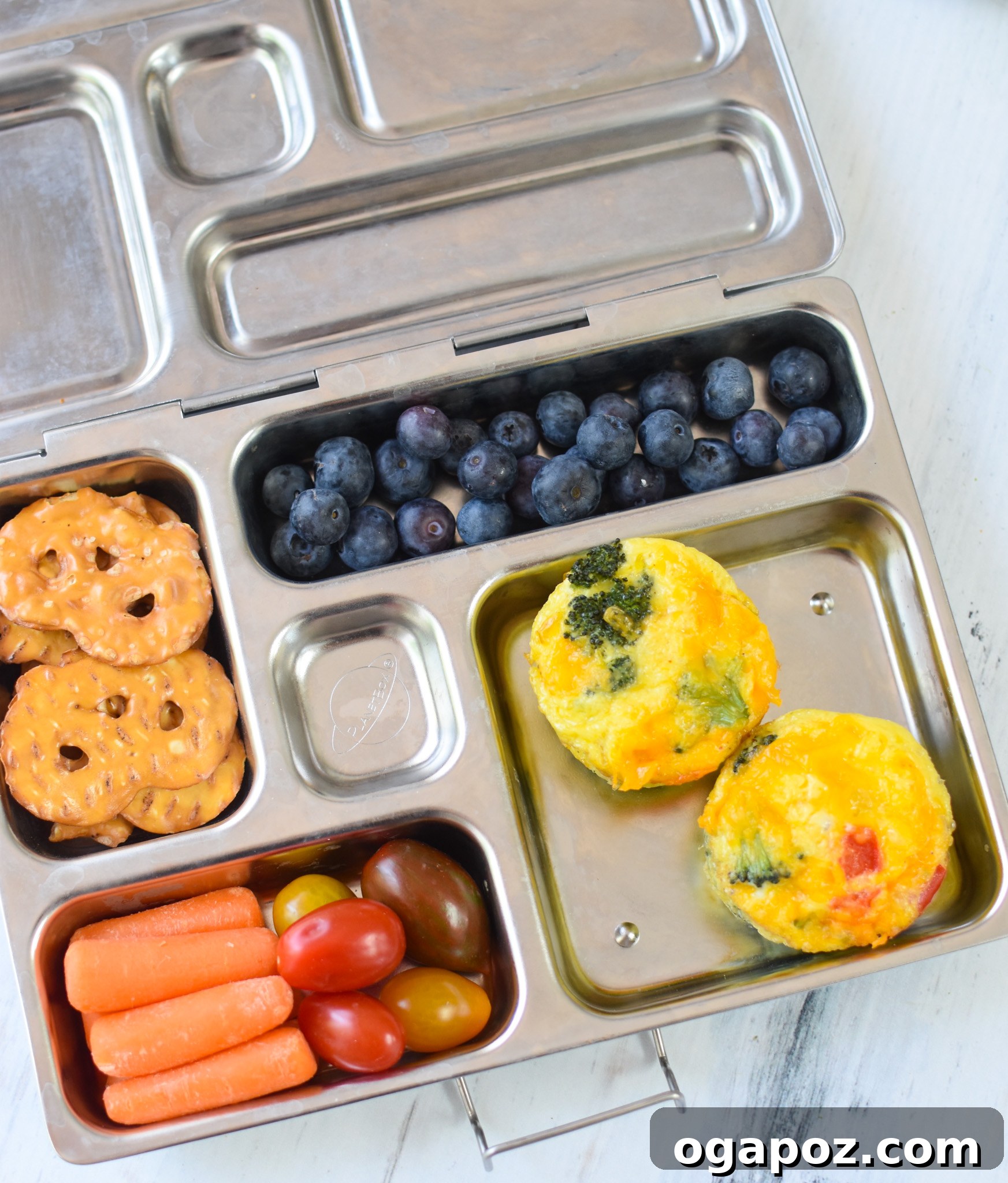 Cheesy Broccoli Bites 4 Broccoli Cheddar Cups neatly packed in a vibrant school lunchbox alongside fresh fruit and other healthy snacks, ready for a busy day.