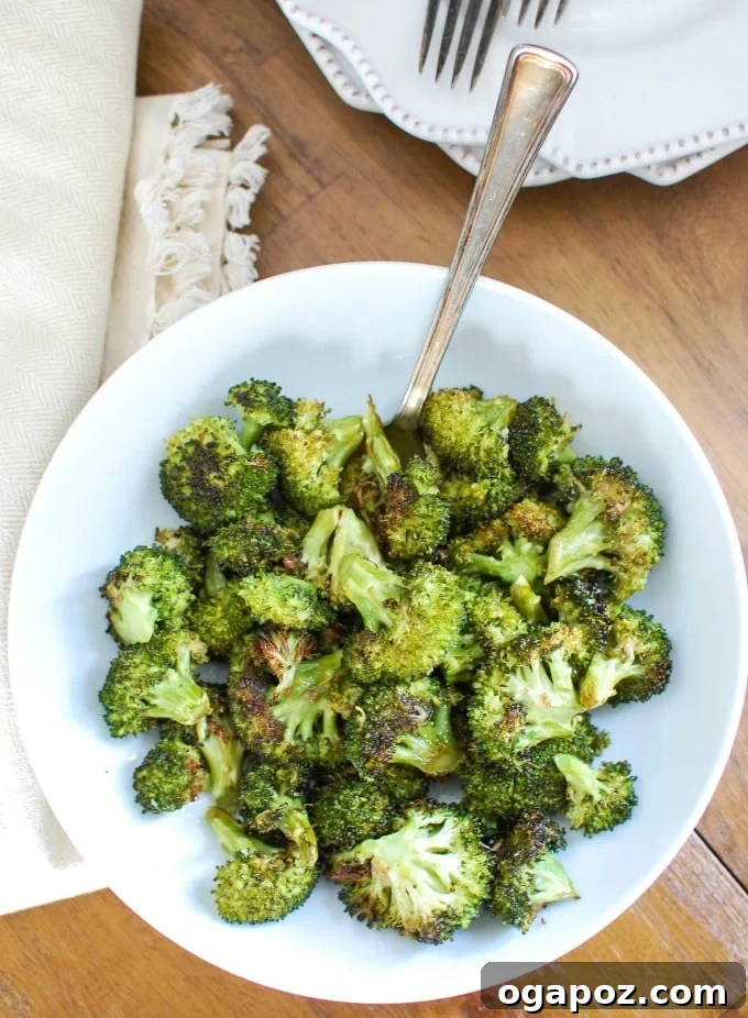 Golden Roasted Broccoli 4 Roasted Broccoli in a serving bowl with a spoon, ready to be enjoyed.