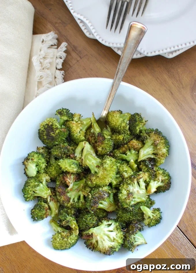 Golden Roasted Broccoli 5 Close-up of roasted broccoli florets with a fork, showcasing crispy edges.