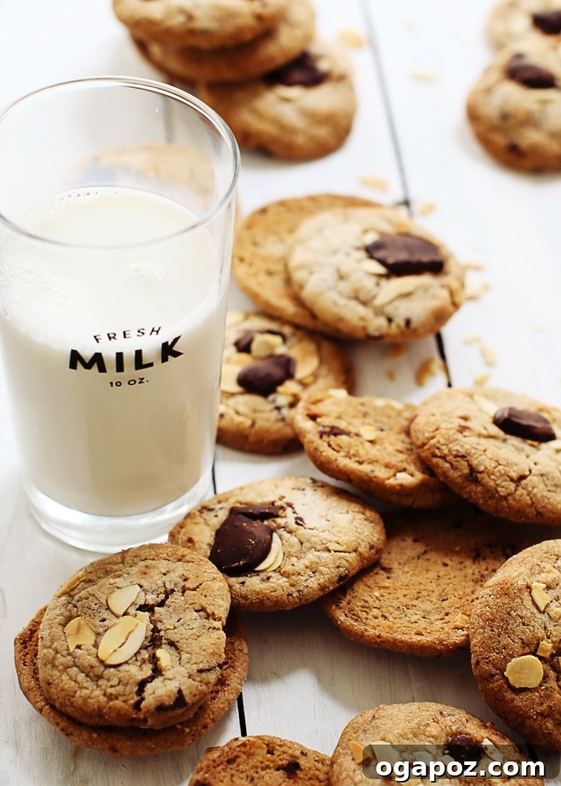 Decadent Chocolate Chunk Almond Cookies 4 A baker's hands gently pressing extra chocolate chunks and almonds onto scooped cookie dough balls before baking for presentation.