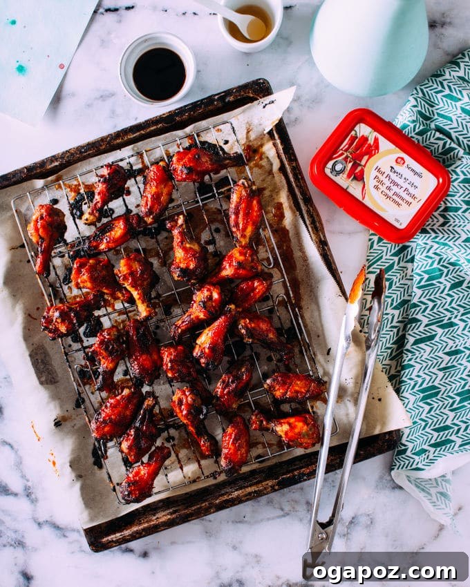 Korean Glazed Chicken Wings 4 A large platter generously filled with sticky-spicy Korean chicken wings, beautifully garnished with vibrant green onions and crunchy toasted sesame seeds, ready to be served.