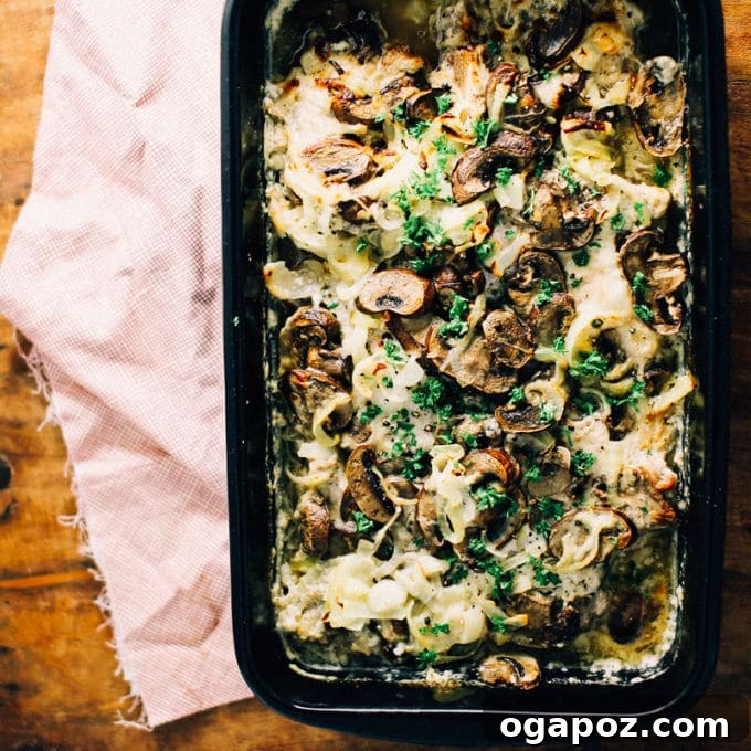 Savory Baked Pork Chops Smothered with Onions and Mushrooms 3 Close-up of a single smothered pork chop with creamy mushroom gravy and fresh parsley