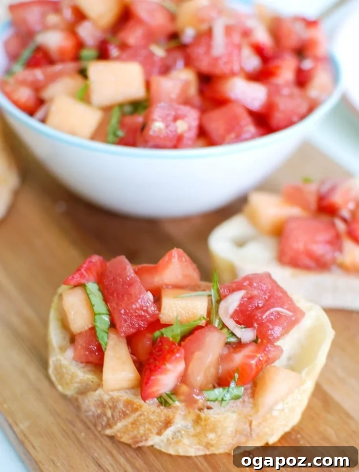 Sun-Kissed Berry Melon Bruschetta 3 Close-up of freshly diced tomatoes, watermelon, cantaloupe, and strawberries, ready for Berry Melon Bruschetta.