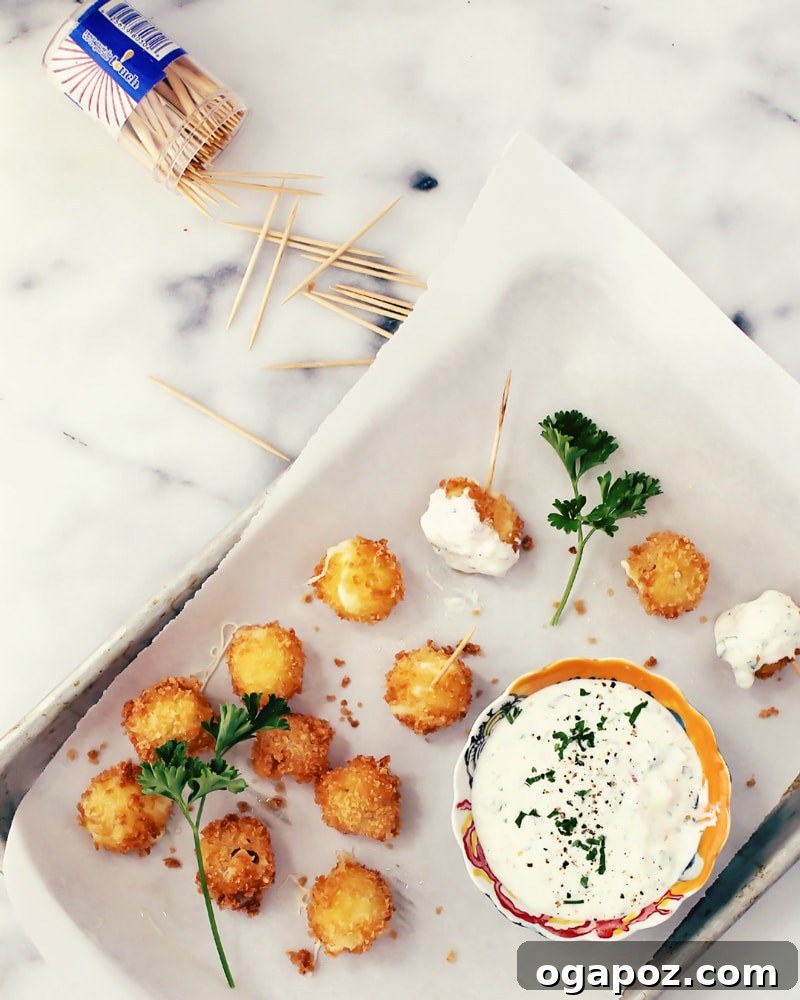 Crispy Mozzarella Bites with Zesty Jalapeño Ranch 4 Raw bocconcini balls coated in panko breadcrumbs, ready for frying.