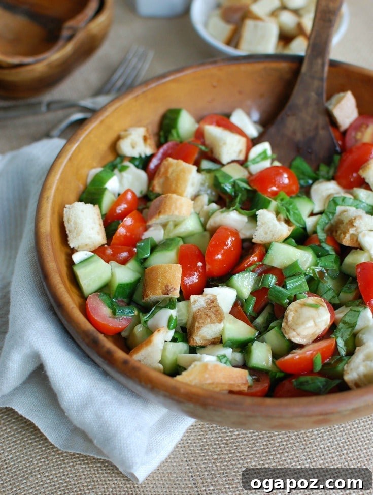Summer Caprese Bread Salad 5 A serving of Caprese Panzanella in a white bowl, showcasing the fresh, colorful ingredients ready to be enjoyed.