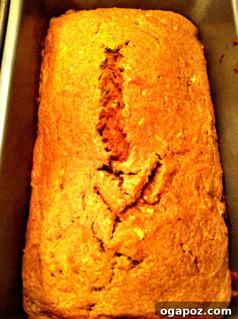 Two freshly baked loaves of Pumpkin Zucchini Bread on a cooling rack