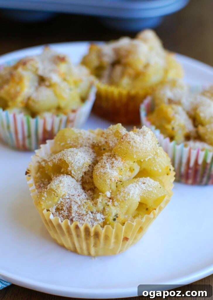 Cheesy Mac Bites 4 Freshly baked Mac and Cheese Muffins cooling in a muffin tin, ready to be removed.