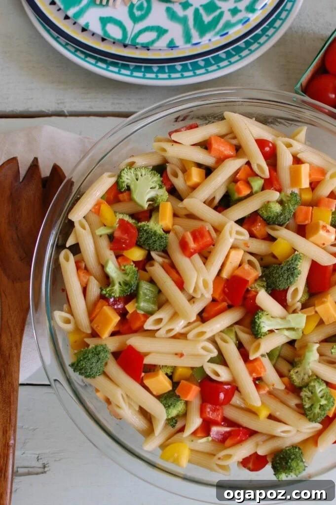 The Ultimate Pasta Salad 4 Serving bowl of Classic Pasta Salad, brimming with fresh ingredients and a savory dressing, ready for a summer picnic.