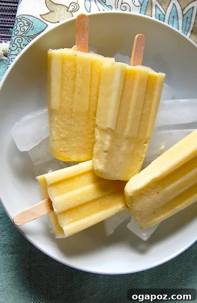25 Ice Pop Sensations to Conquer Summer Heat 3 Pina Colada Popsicles with fresh pineapple and coconut flakes, perfect for a tropical summer cool-down.