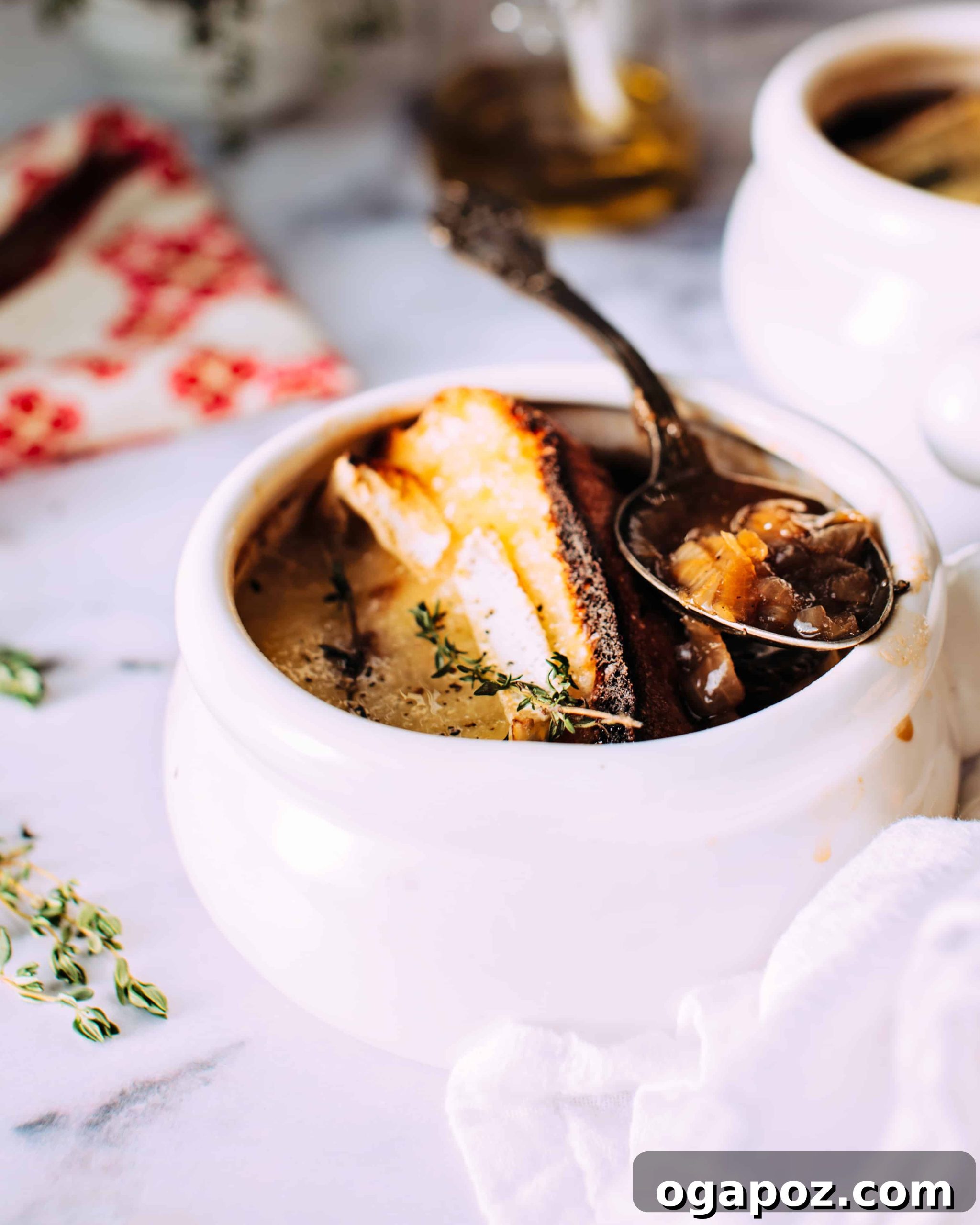 French Onion Soup with Golden Brie Crowns 2 A steaming bowl of French Onion Soup topped with a golden, bubbly brie crouton, ready to be enjoyed.