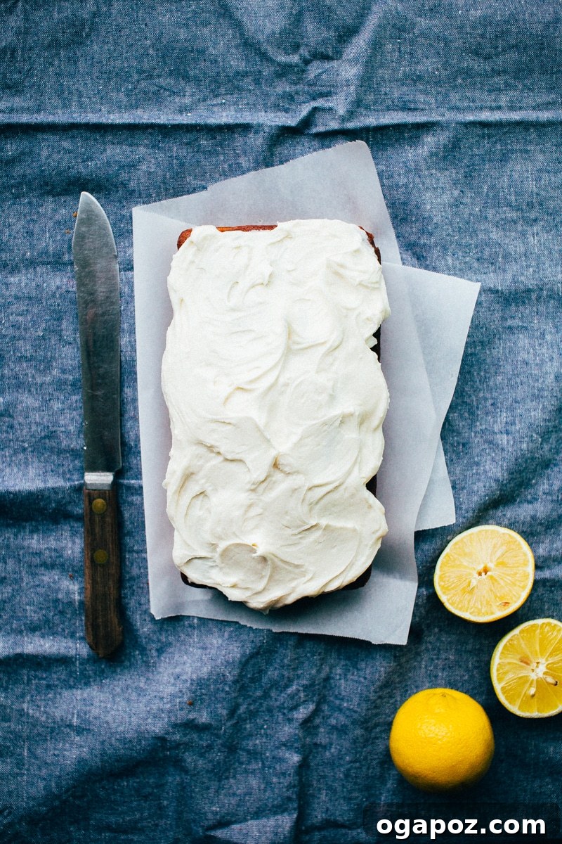 Sunshine Lemon Loaf 4 Lemon Pound Cake loaf cooling on a wire rack after being glazed, ready for frosting.