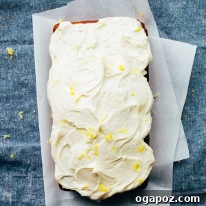 Finished Lemon Pound Cake on a white plate, showcasing its golden crust, lemon glaze, and creamy frosting.