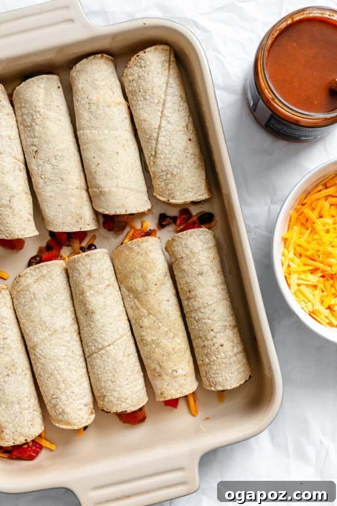Effortless Vegetarian Enchiladas 11 Rolled vegetarian enchiladas arranged in a baking dish before sauce and cheese.